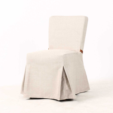 Three quarter front view of the Carlyle Dining Chair featuring its tailored skirted silhouette and luxurious textured upholstery.