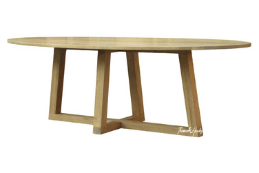 The Ovalis Dining Table by Thomas & Hurley, a contemporary oval timber dining table with sculptural angled trestle base, photographed from the front angle highlighting the modern luxury design and natural wood grain.