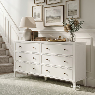 Lando 6 Drawer Chest in white styled beneath a gallery wall beside a staircase, featuring six spacious drawers, bronze knobs and classic Hamptons-inspired detailing.