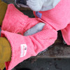 Dog owner wearing pink Gauntlets from Dogrobes over her jacket and using the dog drying mitts to dry her dog’s legs and paws.