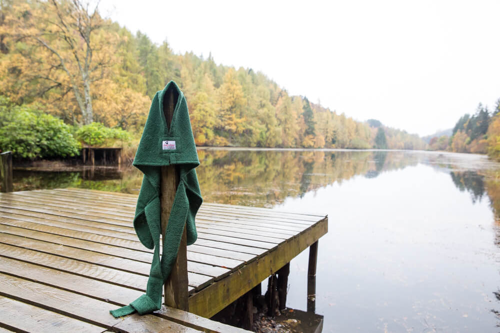 Green Dogrobe hanging on wooden jetty by loch showing lightweight single layer design