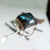 Sterling silver ring with large square-cut Spectrolite Labradorite gemstone showing blue and green iridescence, handcrafted by Crystal Earth Studios. Sterling silver ring with large square-cut Spectrolite Labradorite gemstone showing blue and green iridescence, handcrafted by Crystal Earth Studios.