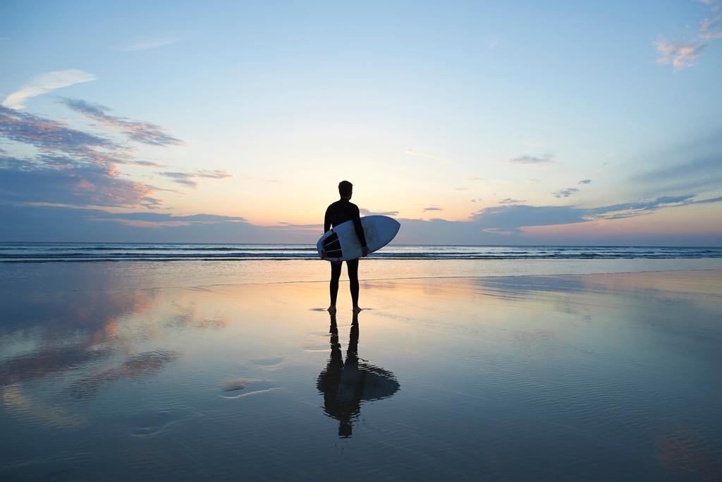 Surfer With Surfboard Deserted Beach At Sunset Ocean Water Surfer With Surfboard Deserted Beach At Sunset Ocean Water