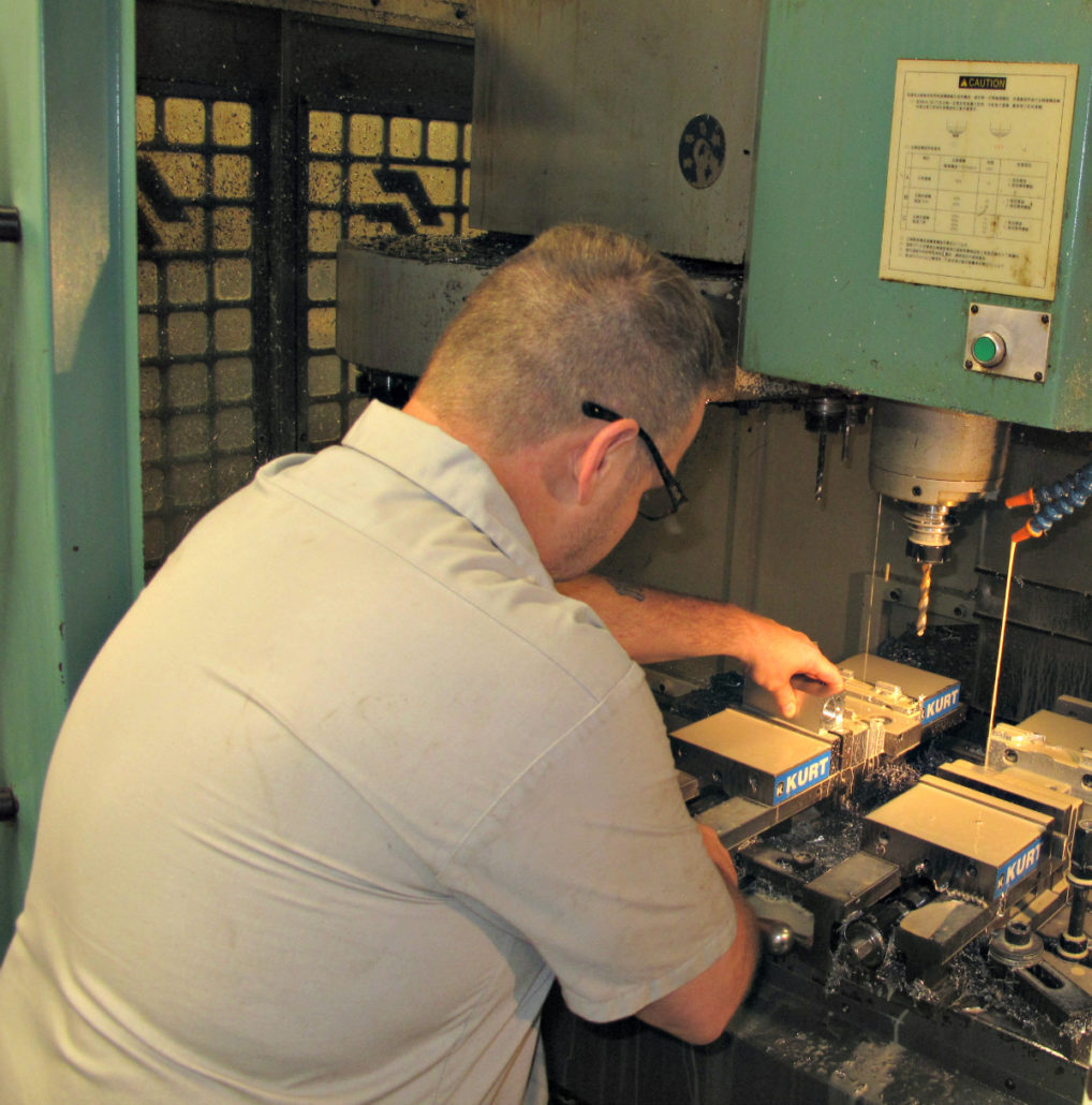 Komo technician working on a machine part
