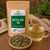 Organic Nettle Leaf Tea in The Tea Hut certified organic kraft pouch, with loose nettle leaves beside a pale golden-green brewed cup.
