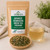 Organic Japanese Genmaicha Green Tea (Premium) in The Tea Hut certified organic kraft pouch, with loose Japanese sencha and roasted brown rice beside a golden-green brewed cup.