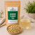 Jasmine Flower Tea in The Tea Hut kraft pouch, with loose dried jasmine blossoms beside a delicately pale golden brewed cup.