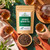 Organic Japanese Hojicha Tea in The Tea Hut certified organic kraft pouch, featuring authentic roasted Japanese green tea leaves and stems with smoky caramel, honey and full-bodied flavour.