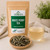 Bulk White Peony Tea in The Tea Hut certified organic kraft pouch, with loose green, russet and silvery white tea leaves beside a pale apricot brewed cup.