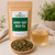 Wildcrafted Horny Goat Weed Tea in The Tea Hut kraft pouch, with loose chopped leaves and stems beside a light earthy-amber brewed cup.
