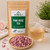 Bulk Pink Rose Tea in The Tea Hut certified organic kraft pouch, with loose pink rose petals beside a pale golden brewed cup.