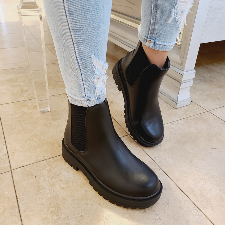 Ankle boots are matte black with thick rubber soles, great for durability and comfort, slip-on style with elastic panels on the sides for ease of wear.