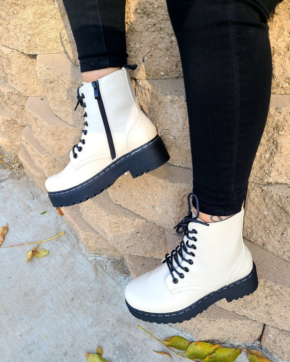 Step into style with these chic Beige combat boots, featuring a sleek design, contrasted by bold black soles and laces. Perfect for making a statement while ensuring comfort and durability