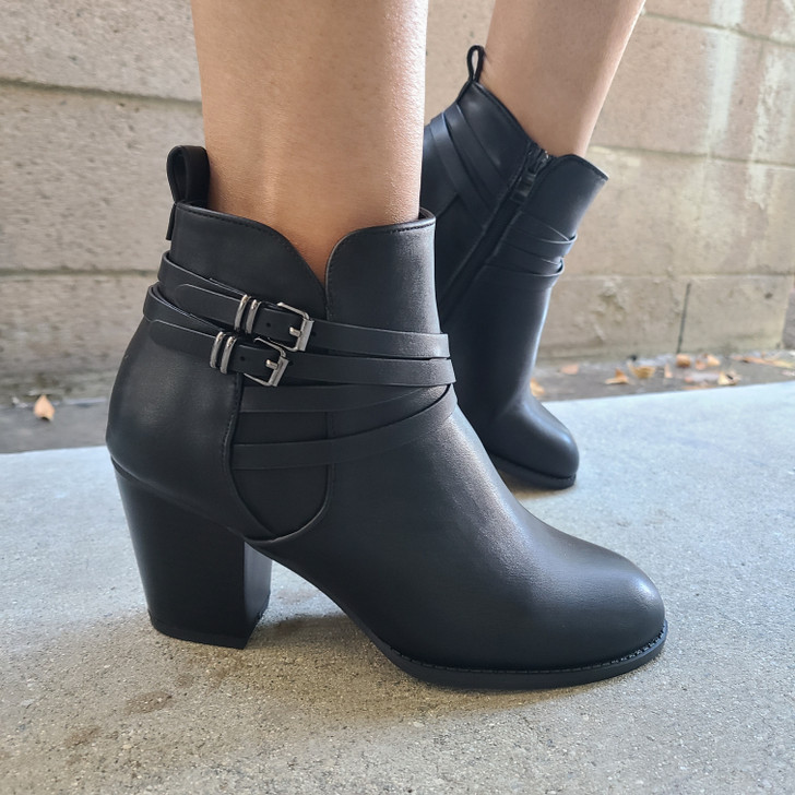 Step into style with these elegant black faux leather ankle boots, featuring a sleek design, zipper detailing, straps with a buckle adornments and a comfortable fit. Perfect for any occasion, these boots combine fashion and function to elevate your look