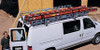 System One Contractor Rig Van Rack with heavy-duty tie-down on white van, extended length.