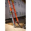 Werner PK100 LevelSafe Pro Series Ladder Leveler, orange, on concrete, attached to ladder as leveling device.