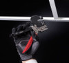 Malco grid punch tool, red and black, in a gloved hand, ceiling grid puncher.