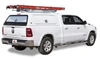 LEER 100SCC Fiberglass Truck Cap on white pickup truck with red ladder rack on top.