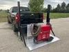 Liftgator TruckGator Hitch-Mounted Liftgate, red, mounted on truck hitch, with coiled hose, sturdy equipment.