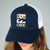Woman wearing a navy and white custom printed trucker hat