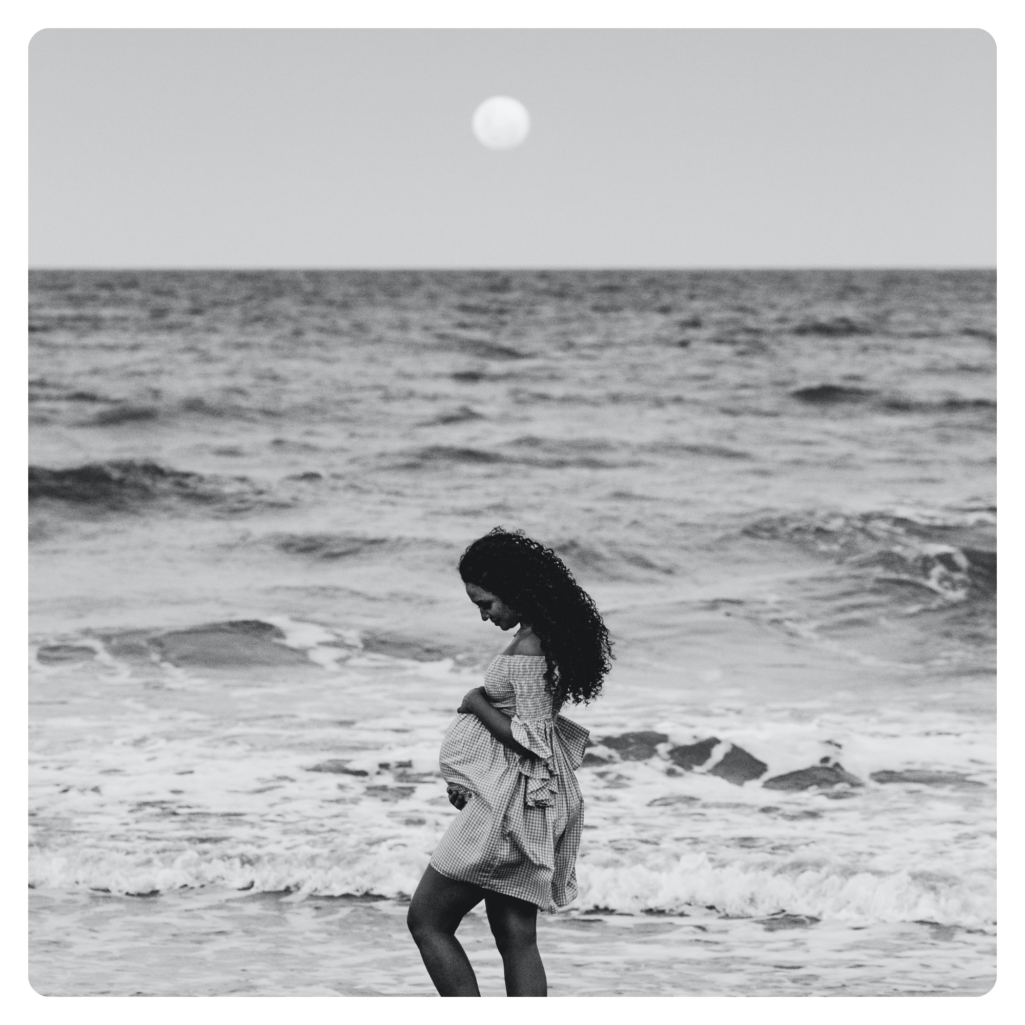 Pregnant woman walking along the beach