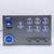 Sophisticated metal switch panel with a red toggle safety cover, a prominent blue ENGINE START button, multiple illuminated metal switches. The panel&#39;s design is both functional and aesthetically modern