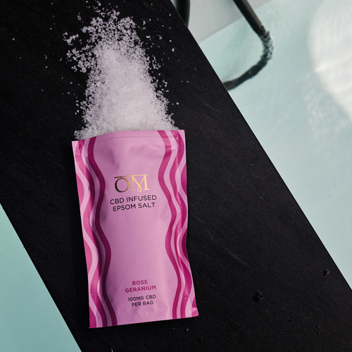 OM Rose Geranium Epsom Salt spilling out of a package near a bathtub OM Rose Geranium Epsom Salt spilling out of a package near a bathtub