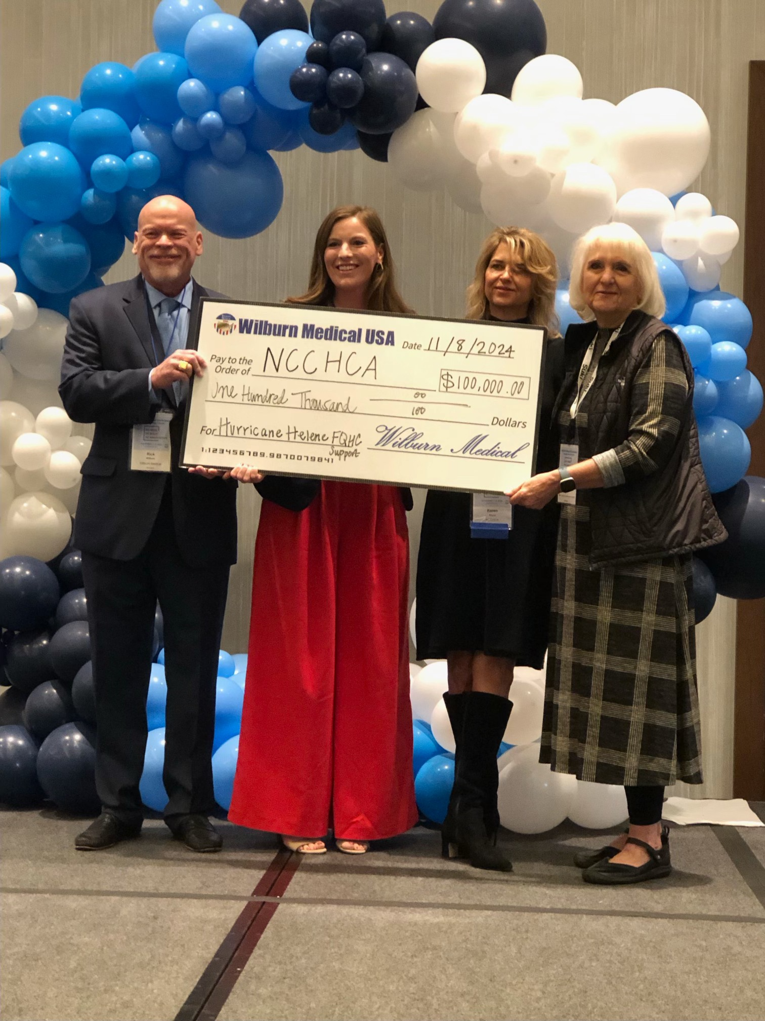 Emily Wilburn Andrews and Rick Wilburn presenting a donation to NCCHCA