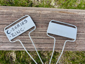 C-Series zinc garden marker with classic angled face plate and galvanized steel legs – ideal for labeling vegetables, herbs, and flowers in garden beds, pots, or raised planters. Weatherproof, rust-resistant, and reusable metal plant tag made in the USA for lasting outdoor use.