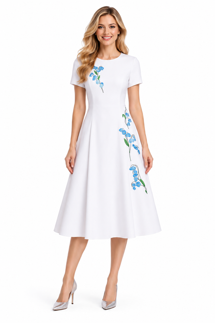 Model wearing a white A-line dress with blue floral embroidery