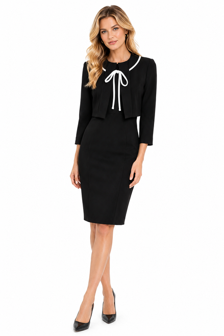 Model wearing a black cropped cocktail jacket with contrast ribbon ties over a sleeveless fitted sheath dress