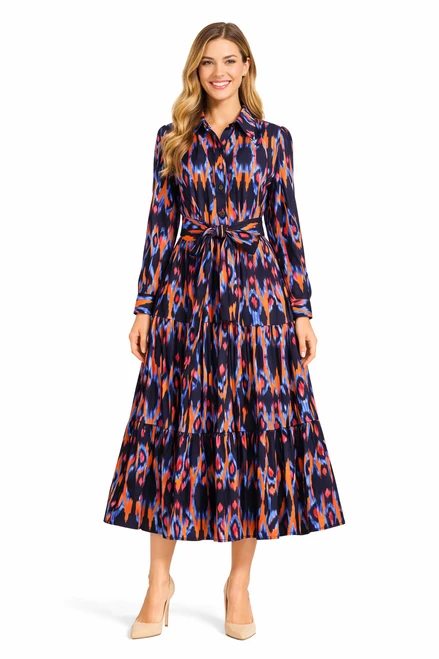 Model wearing a multicoloured ocean blue Ikat print shirt dress with a pointed collar, waist belt and tiered flounced skirt