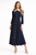 Model wearing a navy polka dot longline shirt dress with a white collar