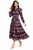 Model wearing a multicoloured ocean blue Ikat print shirt dress with a pointed collar, waist belt and tiered flounced skirt