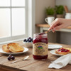 Muscadine jelly spread on toast with a jar of The Dutch Kettle Muscadine Jelly on a wooden breakfast table