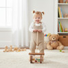 Walnut and Natural Colored Wooden Toy Block Roller with a child pushing it in a playroom.