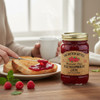 The Dutch Kettle Red Raspberry Jam spread on toast with fresh raspberries and a warm breakfast setting.