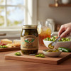 Pickled sweet jalapeños being served from an open jar of The Dutch Kettle Pickled Sweet Jalapenos, styled with fresh salad ingredients and crackers on a kitchen counter.