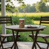 A jar of The Dutch Kettle Amish Home Style Mild Pickled Bologna on an outdoor table next to a plate of the sliced bologna.