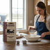 Sifting flour beside the Cooking with the Horse & Buggy People cookbook feels like stepping into an Amish kitchen where simple ingredients and tradition come together.