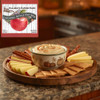 Dip platter with caramel apple dip, apples, crackers, and pretzels on a kitchen counter with Halladay's Caramel Apple Dip Mix from www.harvestarray.com.