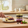 Yoder's Homestyle Loganberry Jam next to a plate with an English Muffin smeared with Loganberry Jam, on a rustic counter in a bright kitchen. Harvest Array where tradition is delivered.