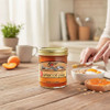 A Jar of Yoder's Homestyle No Sugar Added Apricot Jam and a piece of toast and bowl of granola parfait with this jam on a rustic breakfast table.