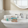 American Coast 2 oz. mini Shea Butter Soap on a small white powder room sink in a powder room with coastal decor.