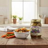 A 17 oz. jar of Jake & Amos Sweet and Sour Chow Chow next to a bowl of this hearty Chow Chow on a wooden kitchen island  in a bright kitchen lit by a large window