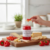 Annie’s Kitchen Red Hot Pepper Jelly served with cheese, crackers, and fresh peppers in a bright kitchen.