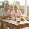 A couple enjoying a jar of Watermelon Rind from Annie's Kitchen with their lunch outside on the back porch, on a summer day.
