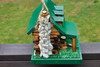 Chimney view of the green wooden double log cabin bird house, sitting on the deck.