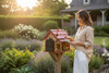 Amish-made log cabin wooden mailbox with red roof being used in a landscaped front yard at a country home.
