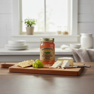 Scuppernong jelly is good with cheese and crackers, pictured on a cheese board with grapes.